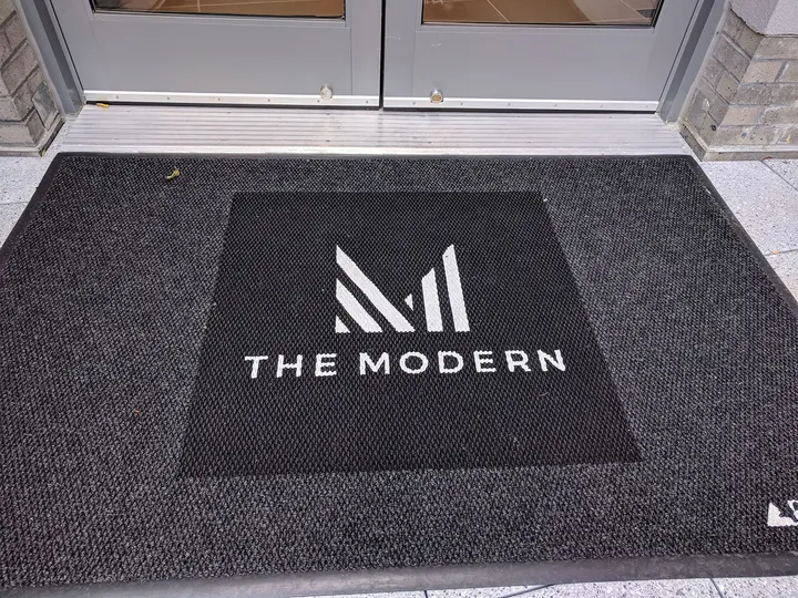 The Modern branded welcome mat with colorful logo design