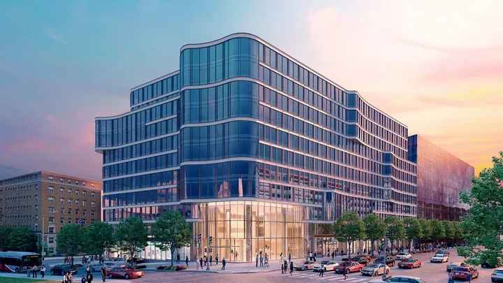 Dusk view of 2100 Penn with illuminated facade and evening cityscape