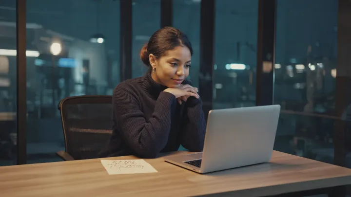 A marketing executive beside a handwritten note and her laptop